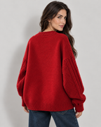Women's oversized cable knit button-down cardigan, red-rear view on Avery & Mercer model