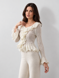 Cream ruffle knit top, W02 front view with natural wall shadow