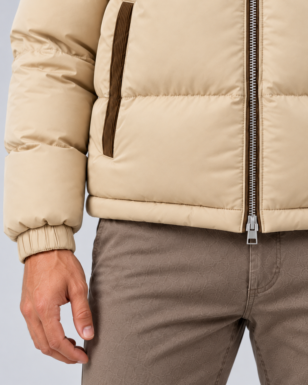 Men's hooded quilted puffer jacket in beige, hem and lower zipper detail, photographed on the approved studio model
