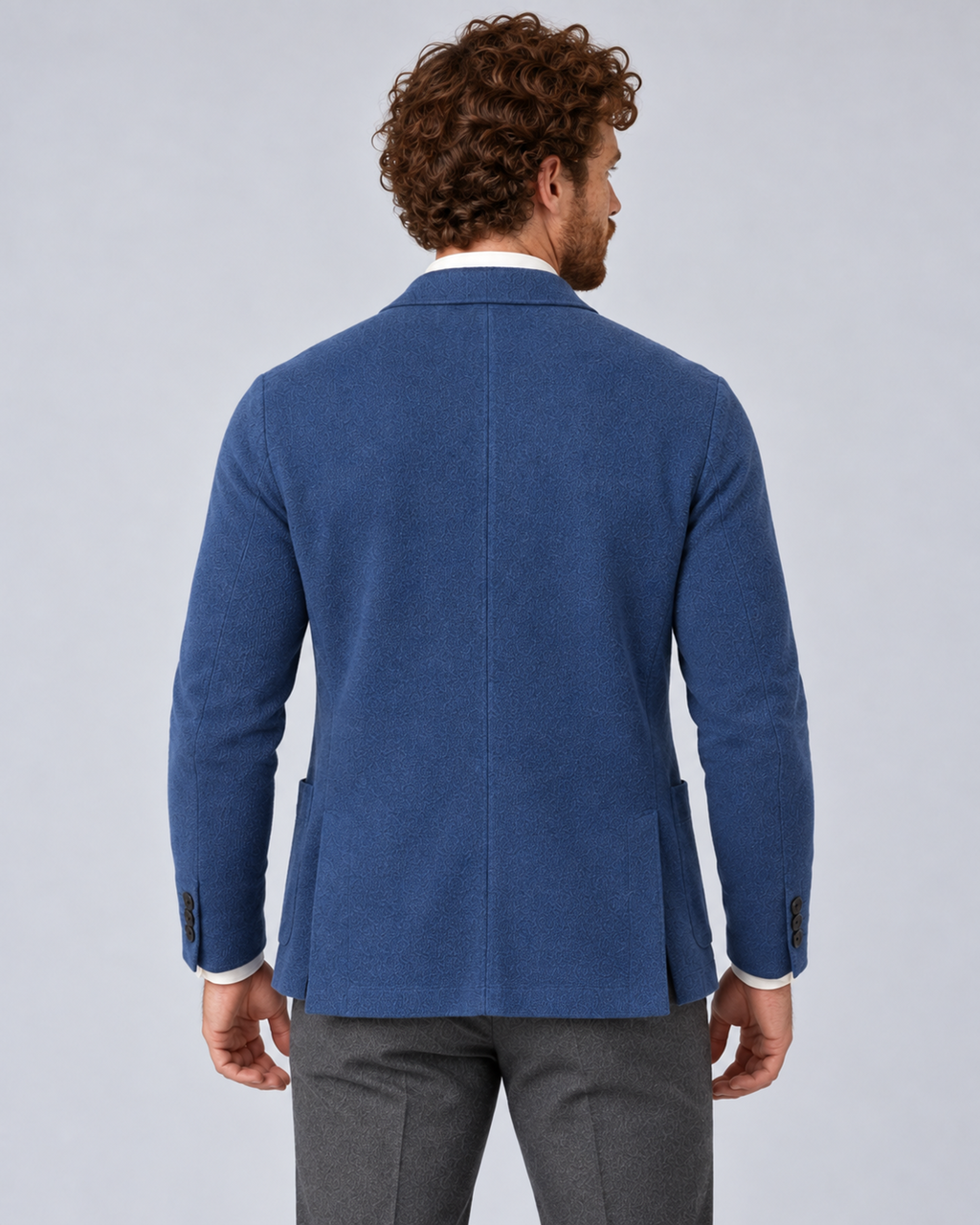 Men's knit blazer jacket in blue, rear, photographed in a grey studio