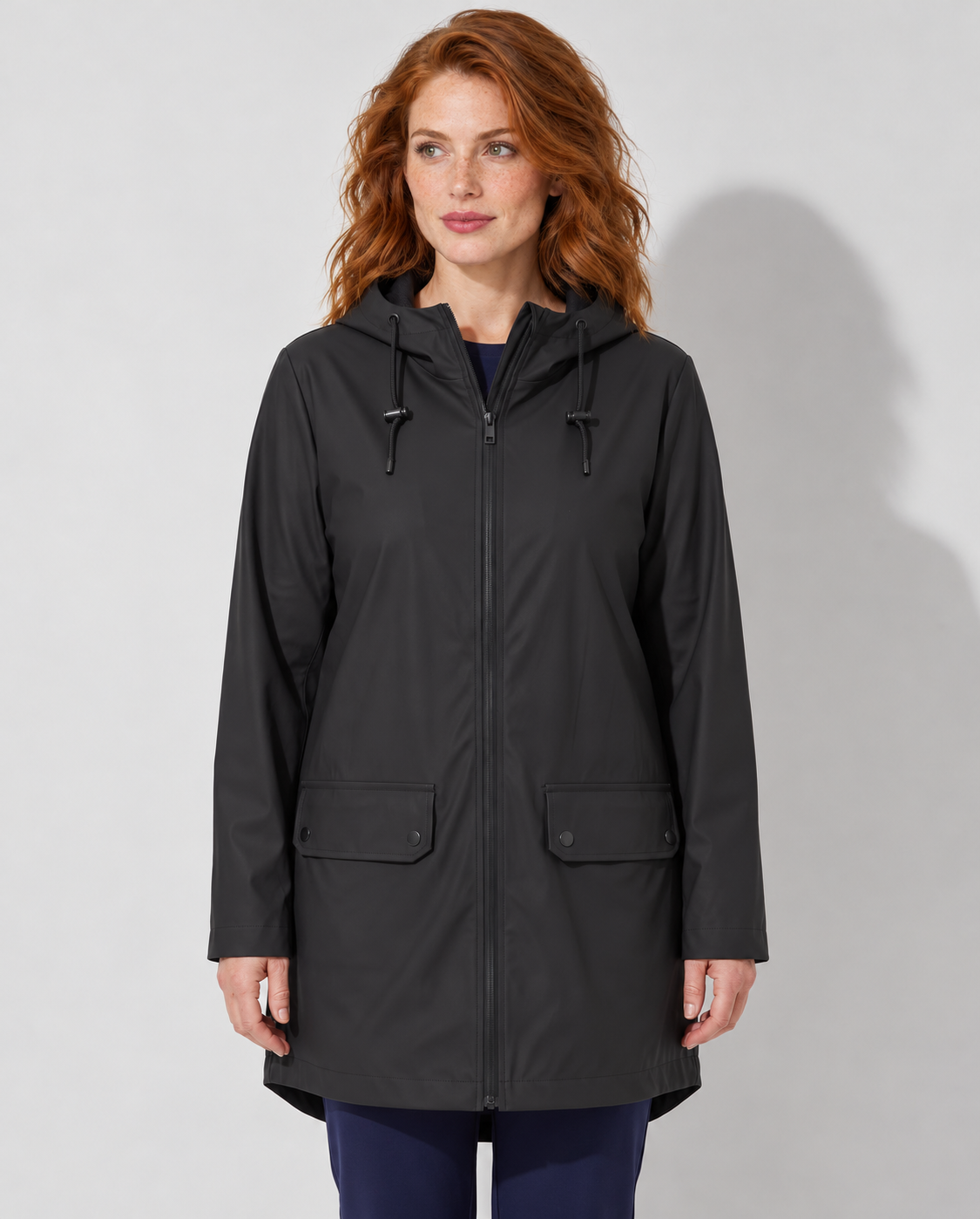 Avery & Mercer model wearing women's long waterproof hooded raincoat in Black, front view