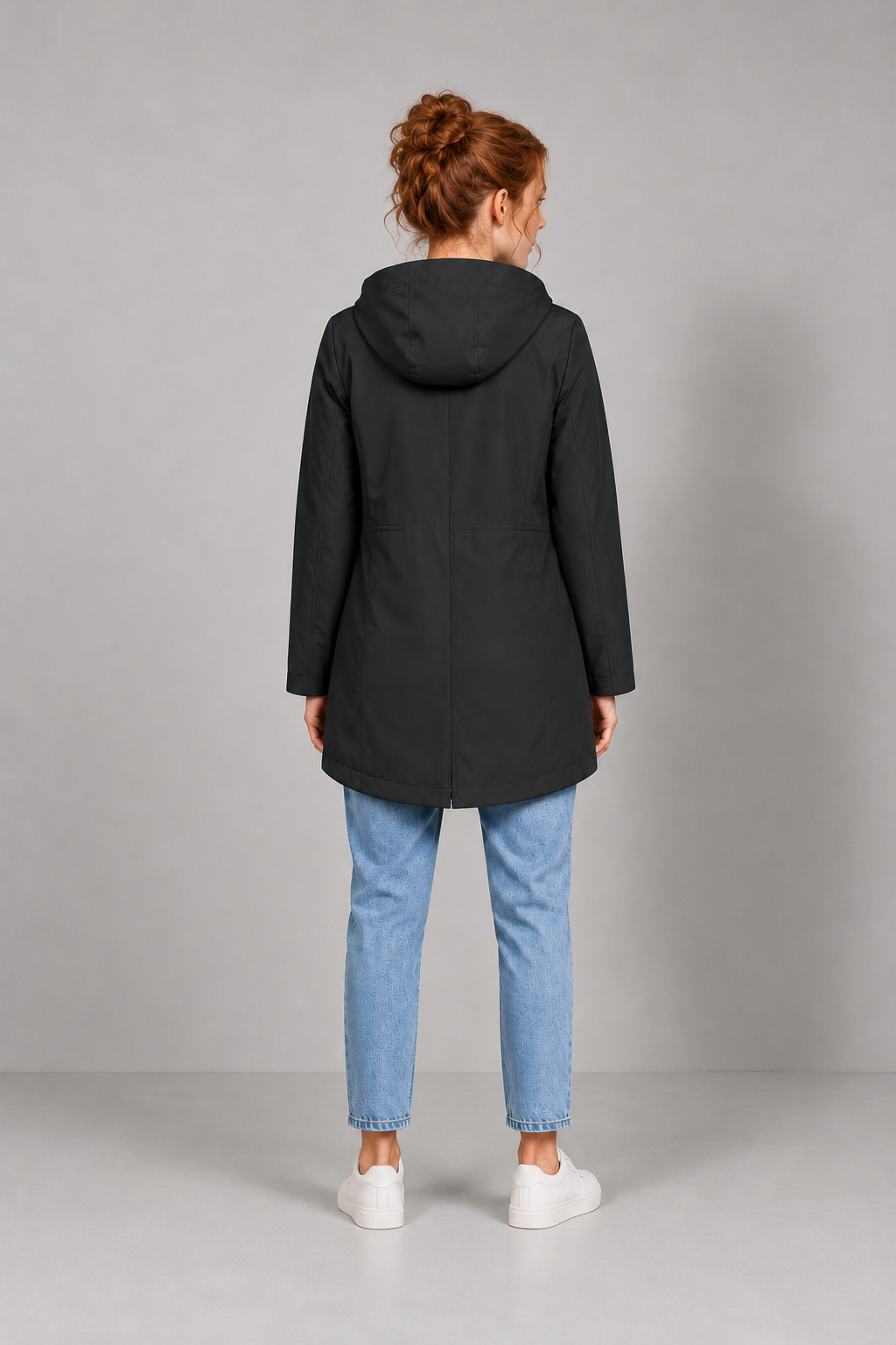 Avery & Mercer model wearing women's long waterproof hooded raincoat in Black, rear view
