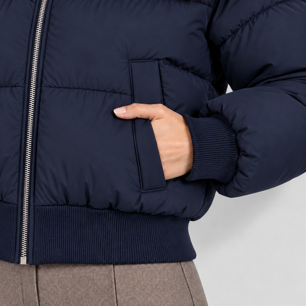Women's cropped puffer jacket in navy, pocket view on Avery Mercer model W01
