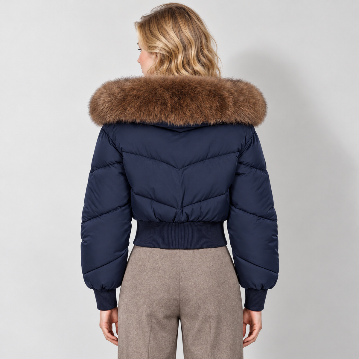 Women's cropped puffer jacket in navy, rear view on Avery Mercer model W01