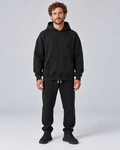 Men's black pullover hoodie and jogger co-ord set, front hero, on approved studio model