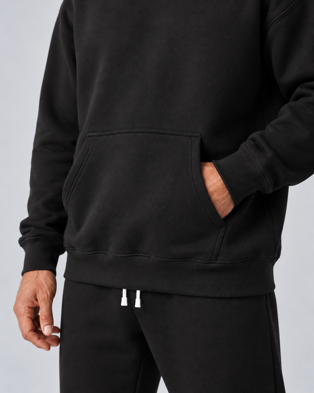 Men's black pullover hoodie and jogger co-ord set, kangaroo pocket, cuff and hem detail, on approved studio model
