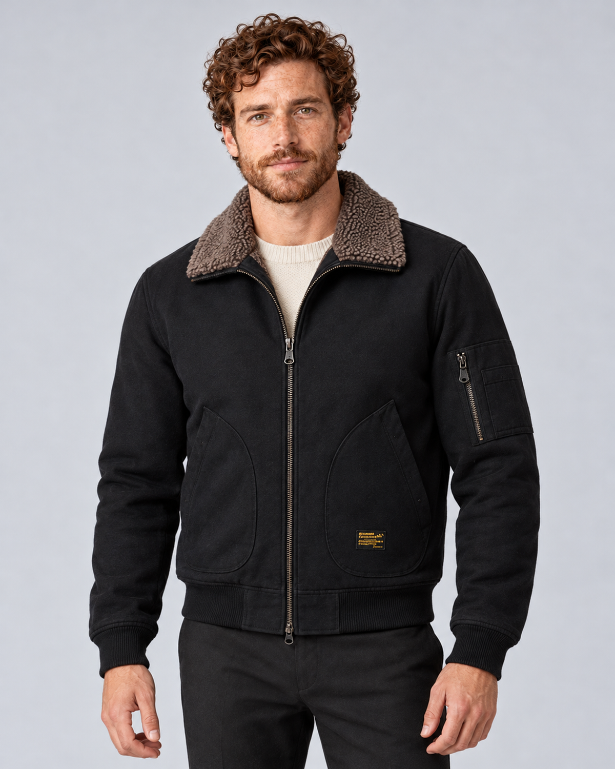 Men’s sherpa-lined zip jacket in black, front hero, photographed against a light grey studio background