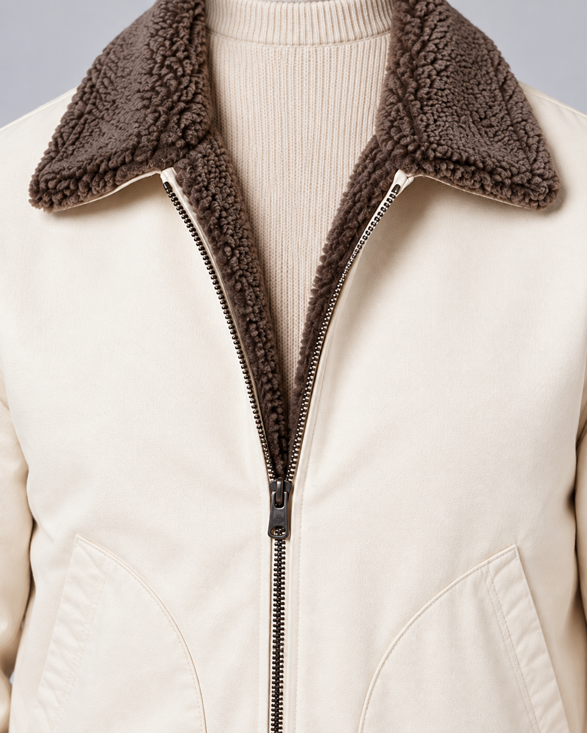 Men’s sherpa-lined zip jacket in white, sherpa lining and zip detail, photographed against a light grey studio background