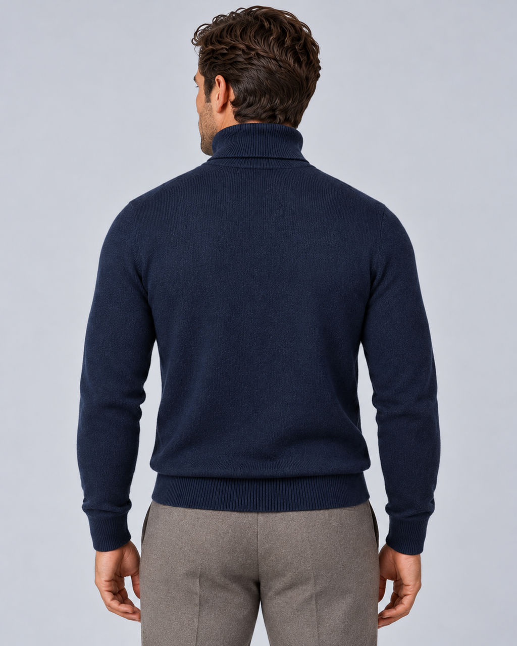 Men's fine-knit turtleneck sweater in navy, rear view, on a male model in a light grey studio