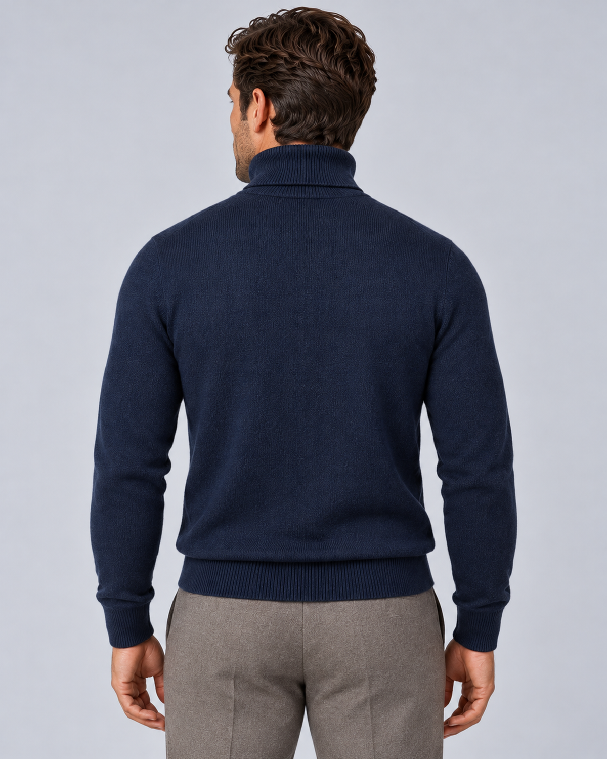 Men's fine-knit turtleneck sweater in navy, rear view, on a male model in a light grey studio