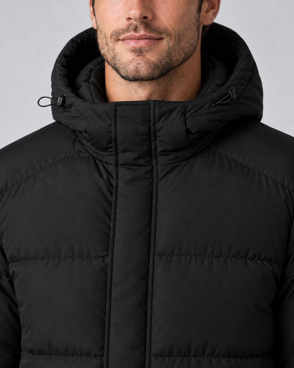 Men's hooded puffer jacket in black, collar and hood detail, on approved studio model