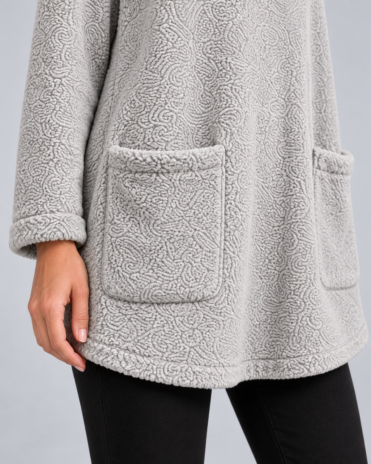 Women's plush hooded tunic in grey, patch pocket cuff and hem detail, photographed in a grey studio