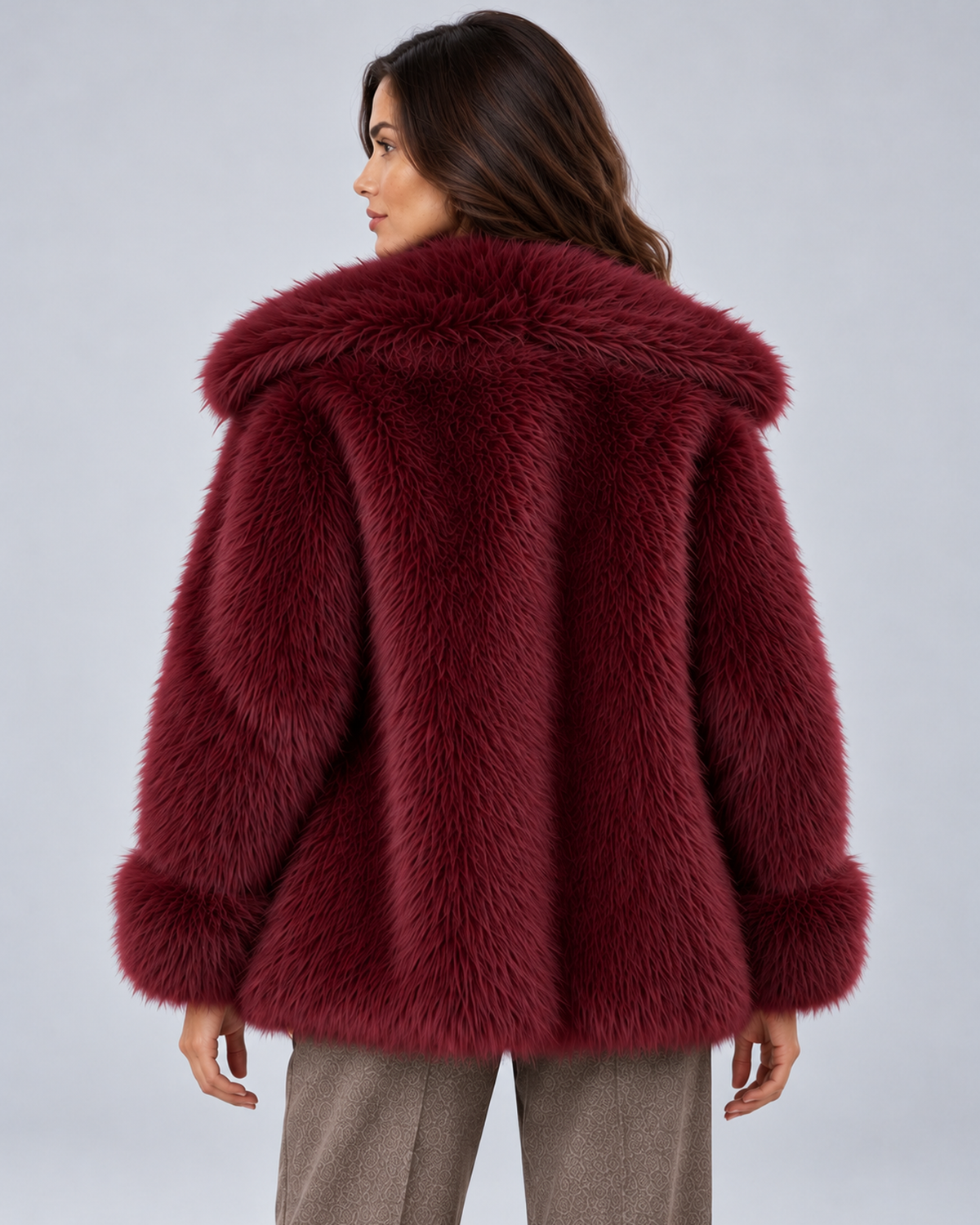Women's short faux fur coat in burgundy, rear view, photographed on a model in a grey studio