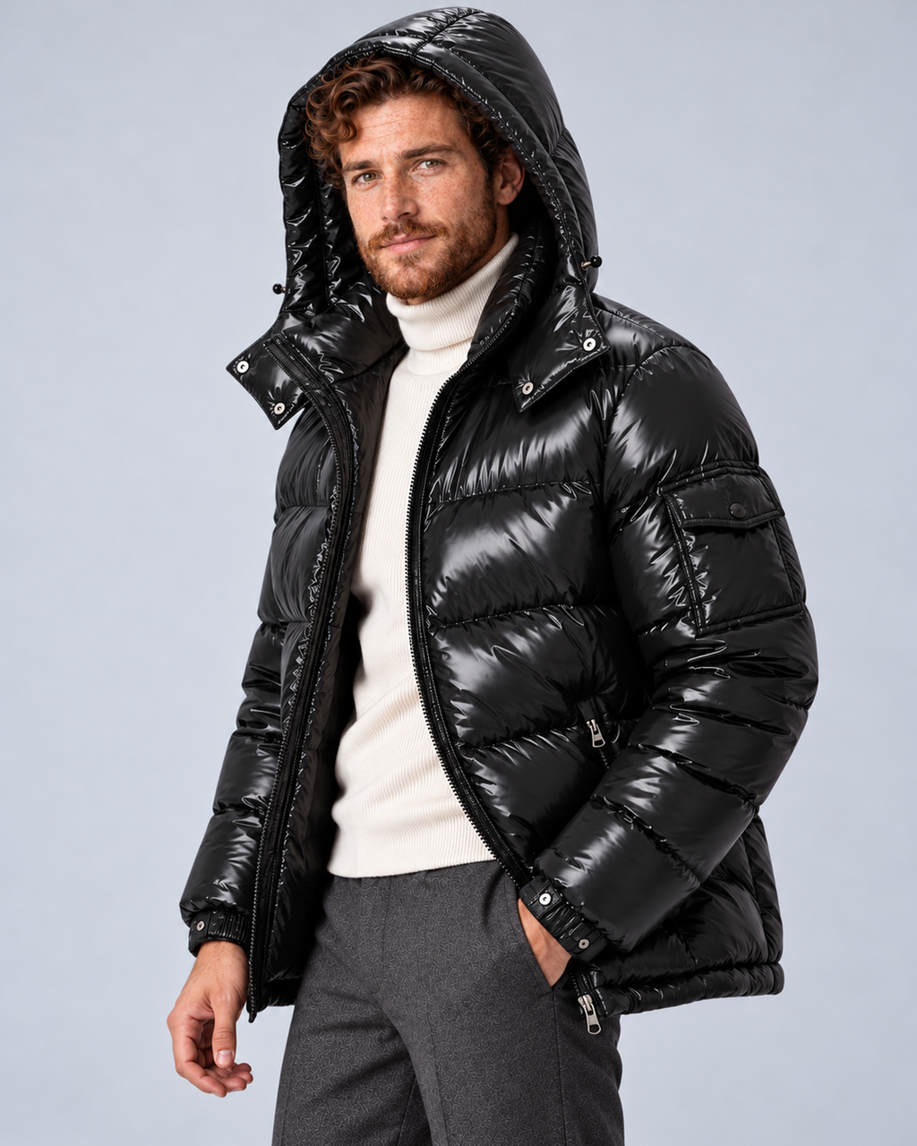 Men's glossy black puffer jacket with removable hood, hood-up three-quarter, on a light grey studio background