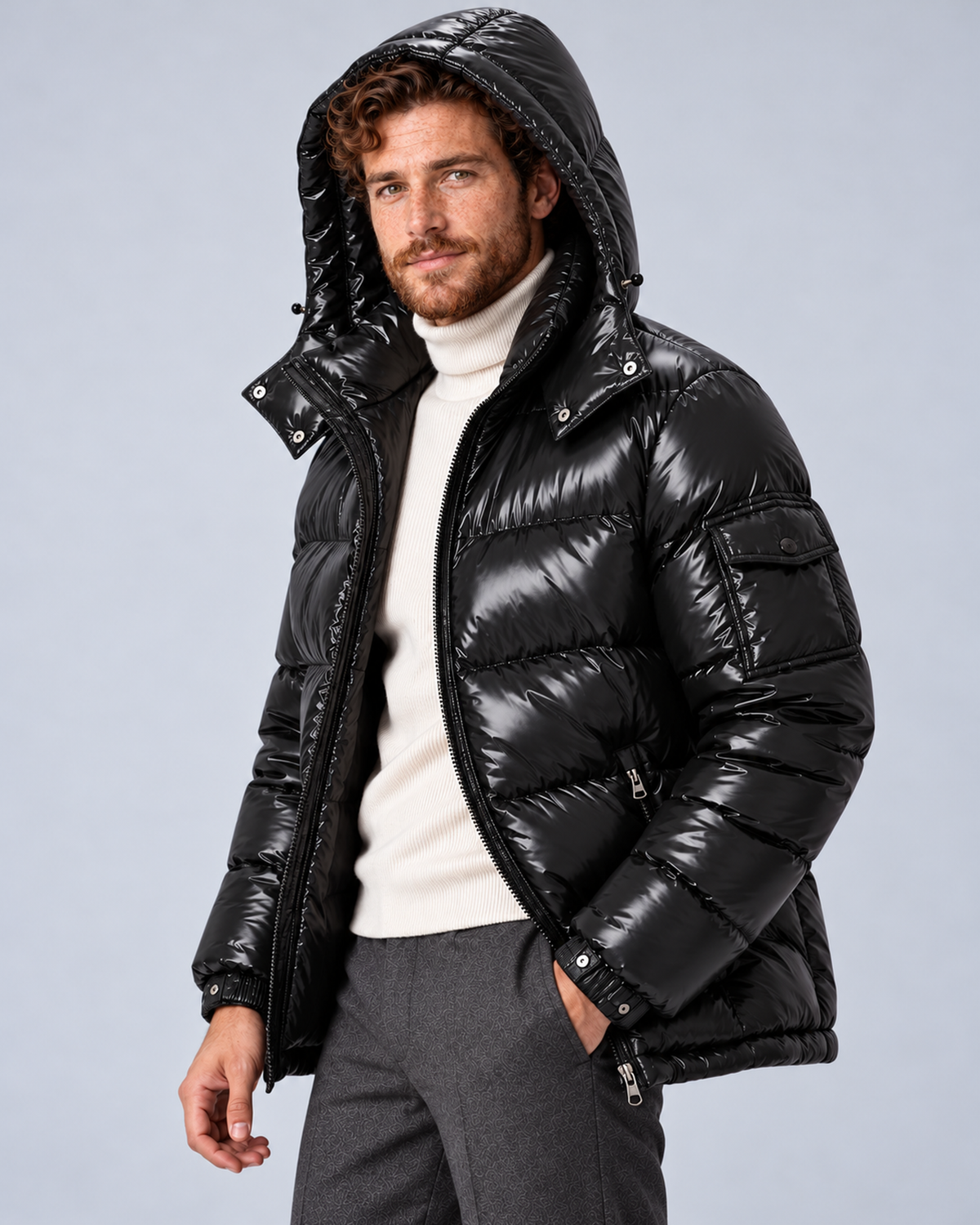 Men's glossy black puffer jacket with removable hood, hood-up three-quarter, on a light grey studio background