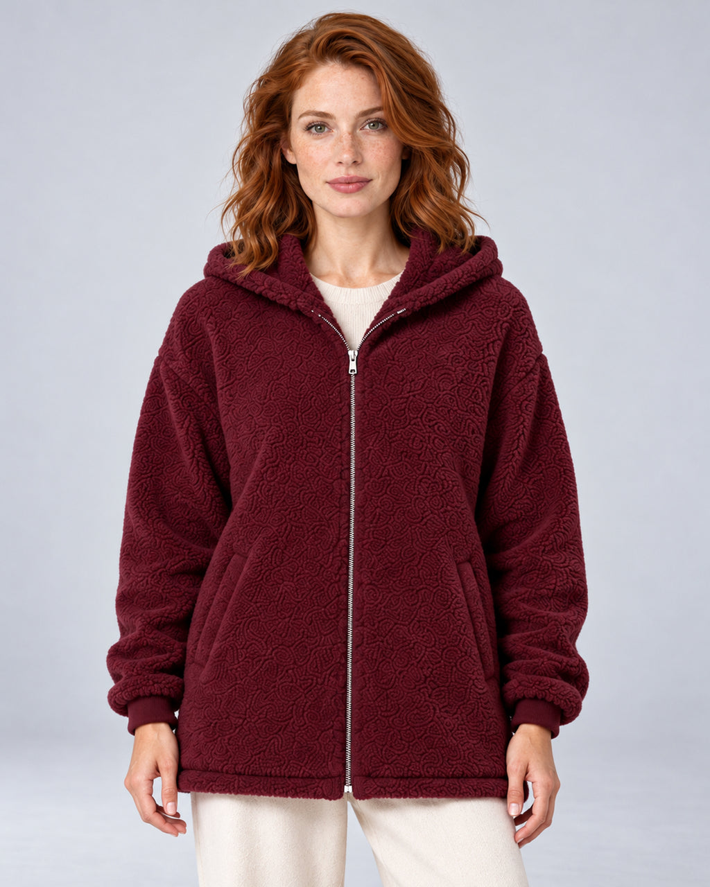 Women's burgundy hooded teddy fleece zip-up cardigan, front view on model.