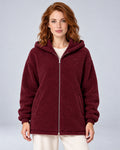 Women's burgundy hooded teddy fleece zip-up cardigan, front view on model.