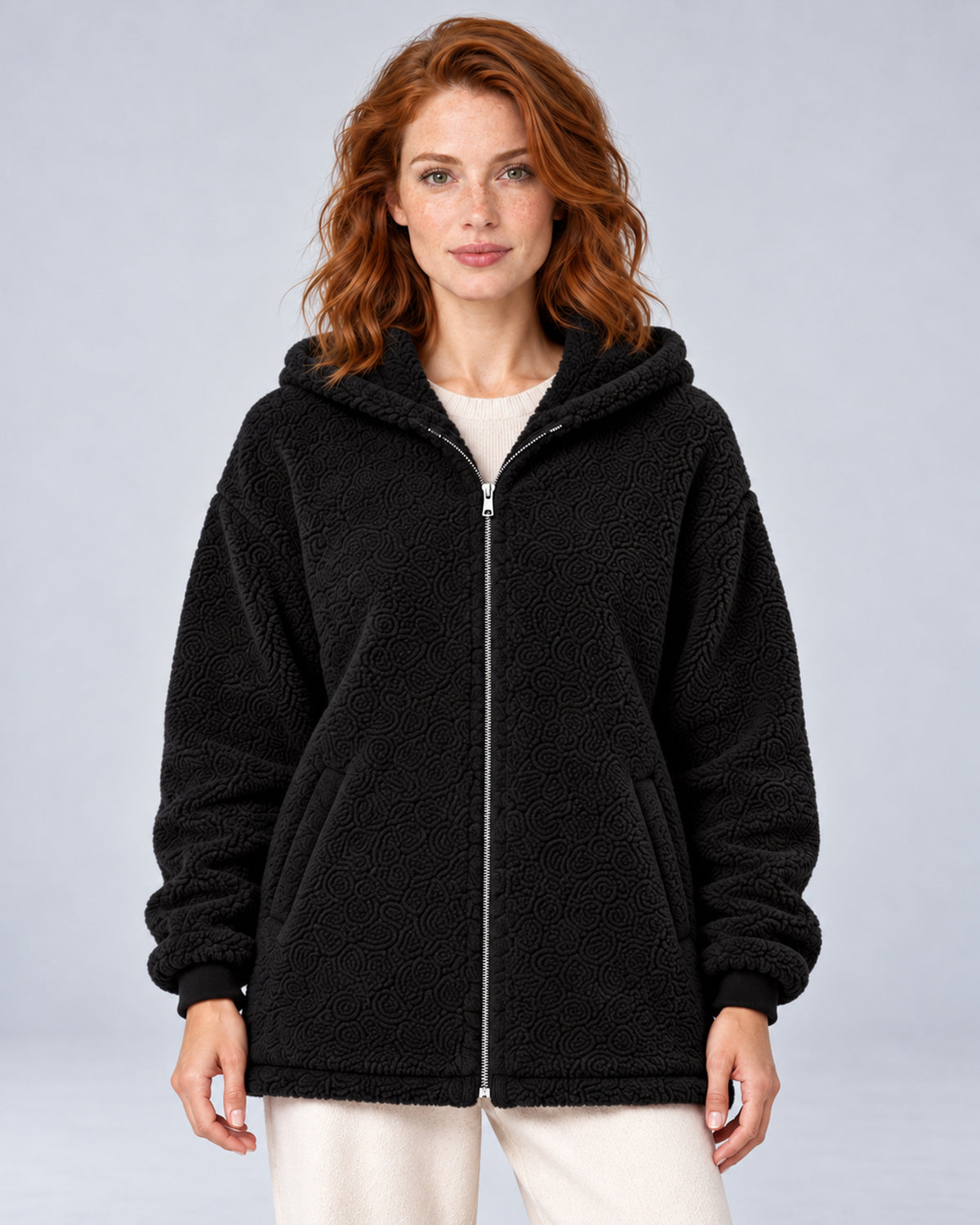 Women's black hooded teddy fleece zip-up cardigan, front view on model.