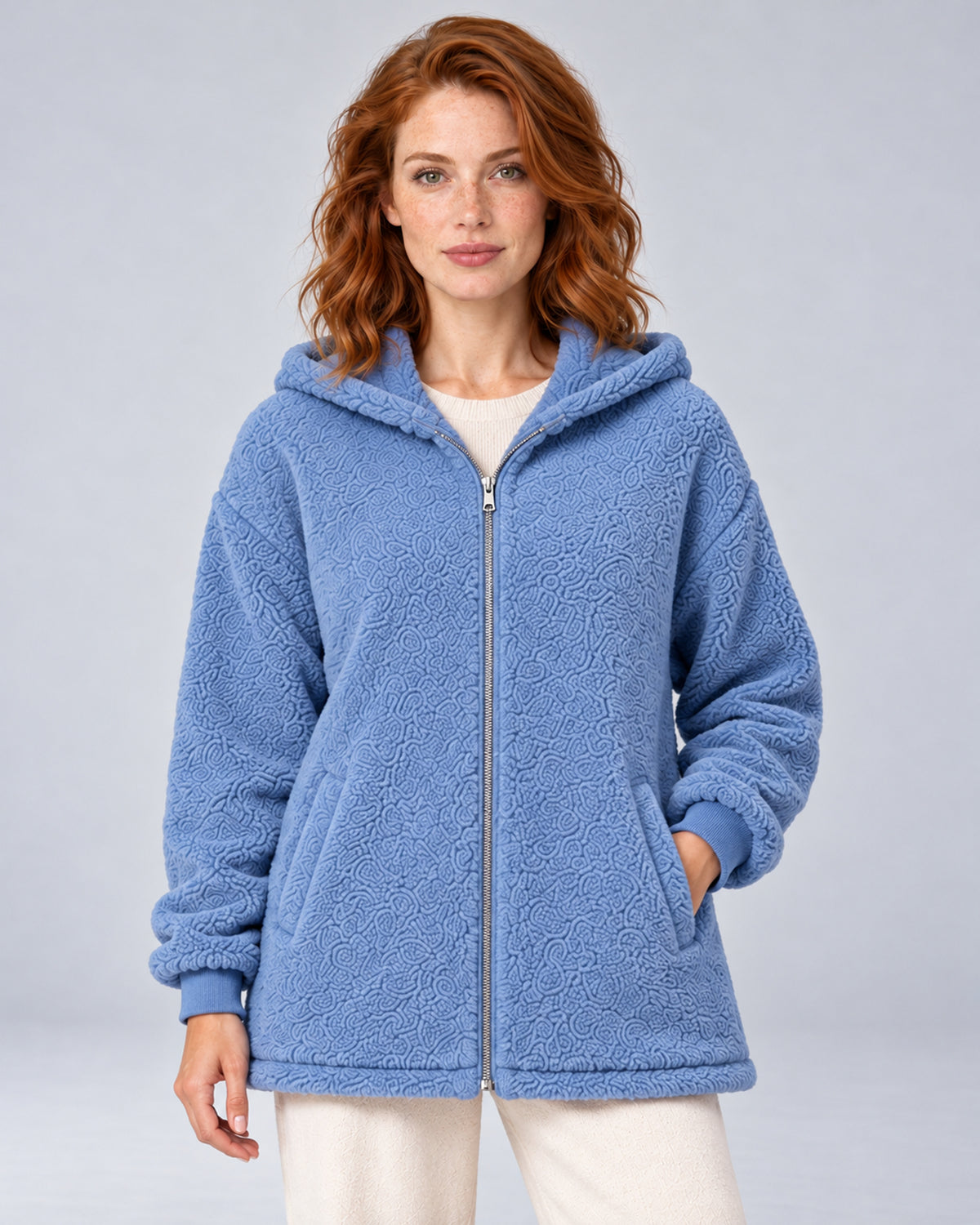 Women's blue hooded teddy fleece zip-up cardigan, front view on model.
