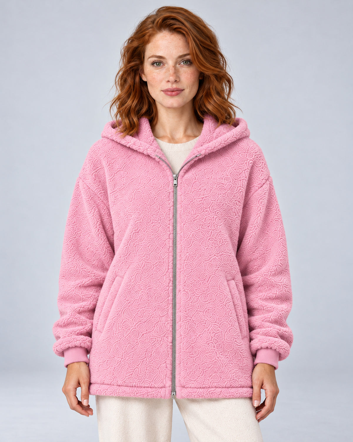 Women's pink hooded teddy fleece zip-up cardigan, front view on model.