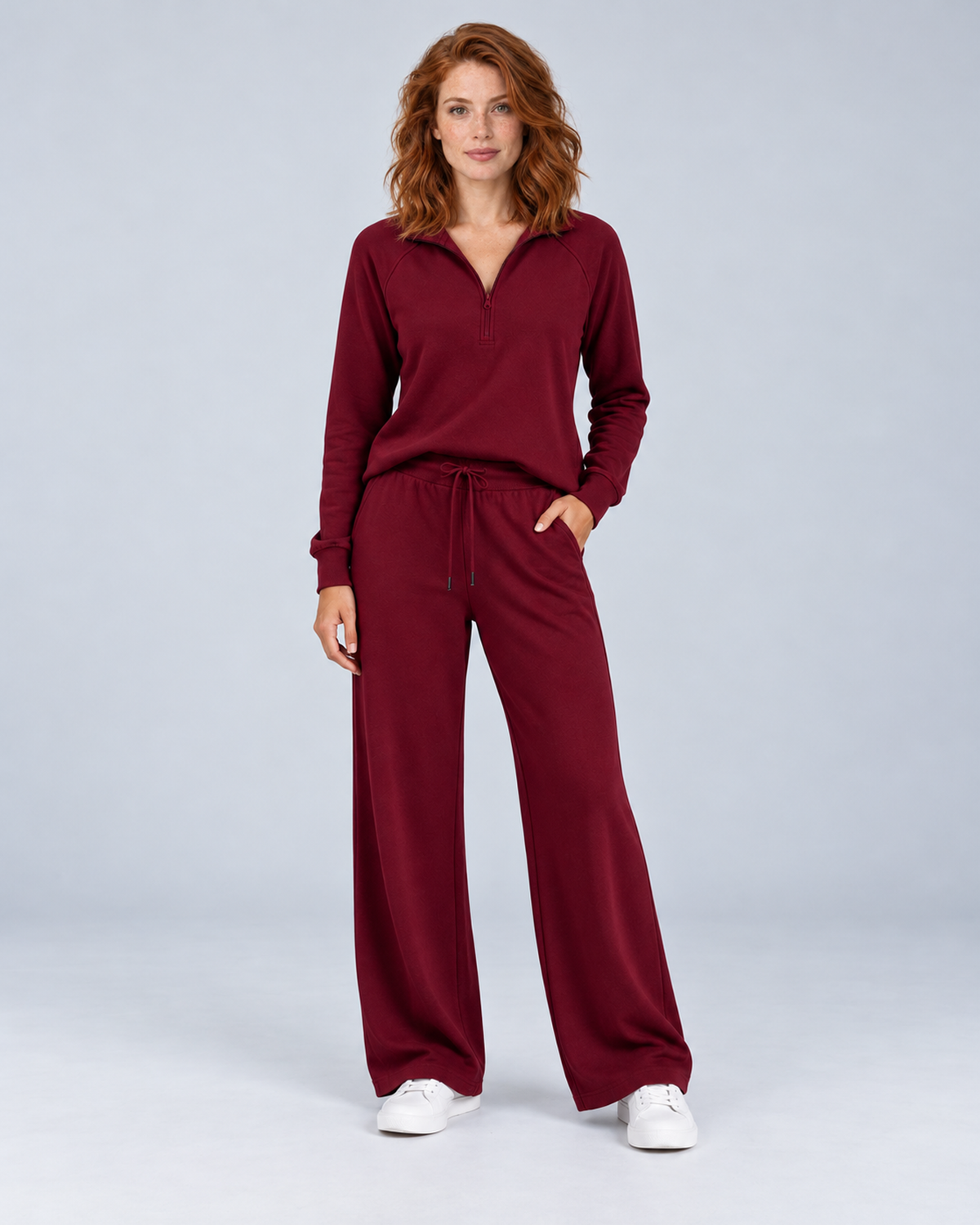 Women's burgundy two-piece lounge set with a half-zip stand-collar top and wide-leg trousers, front view.