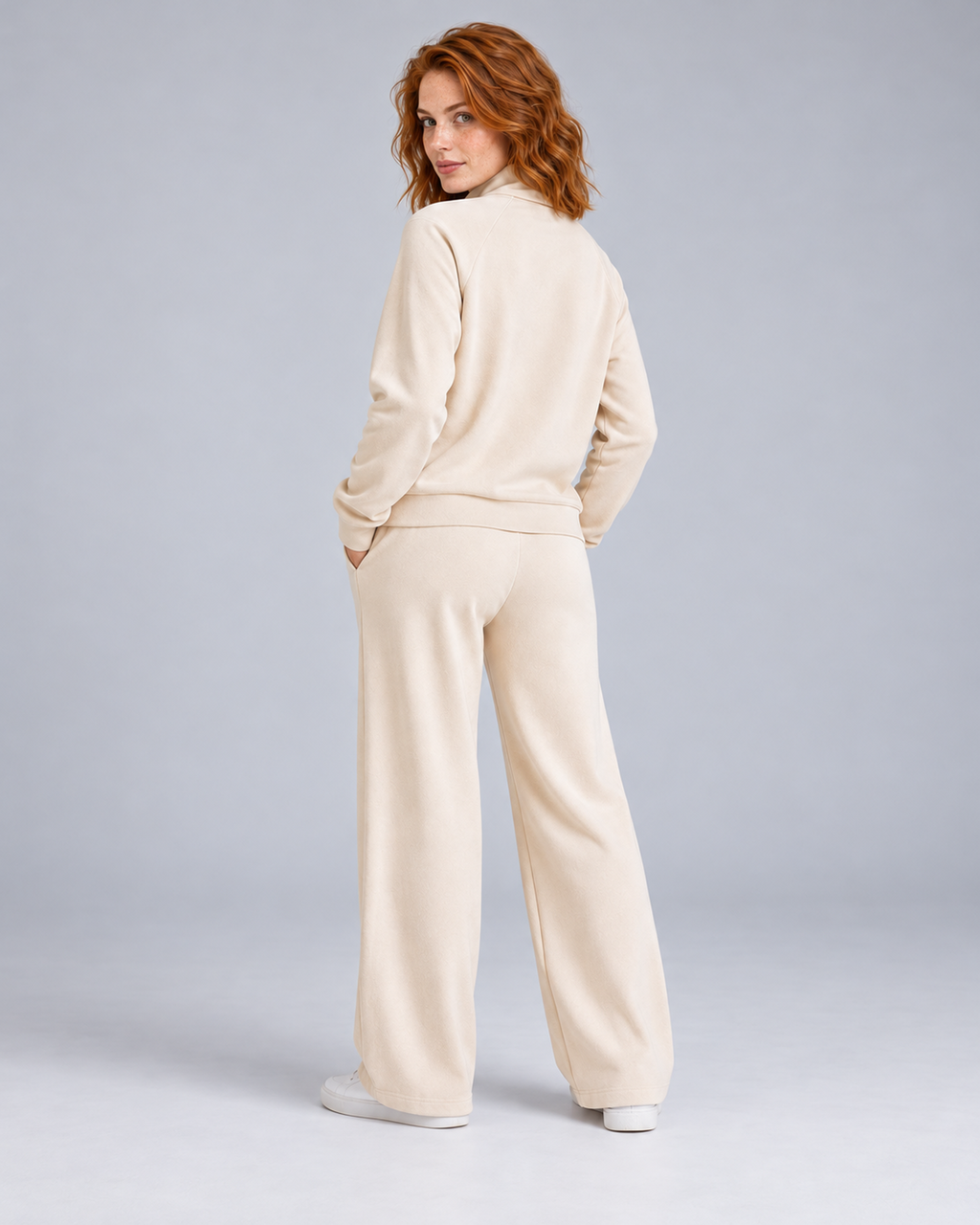 Women's cream two-piece lounge set with a half-zip stand-collar top and wide-leg trousers, rear three-quarter view.