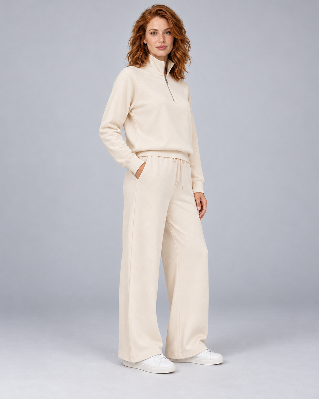 Women's cream two-piece lounge set with a half-zip stand-collar top and wide-leg trousers, front three-quarter view.