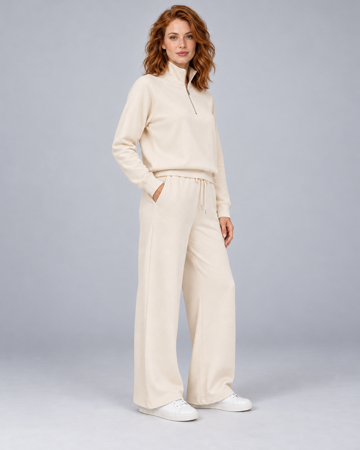 Women's cream two-piece lounge set with a half-zip stand-collar top and wide-leg trousers, front three-quarter view.