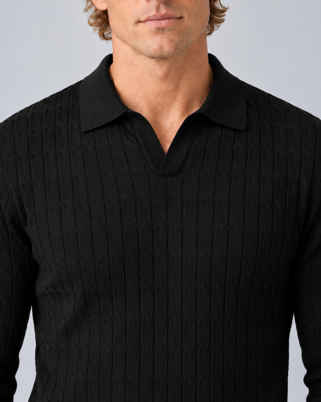 Close-up of the black polo sweater showing the tonal collar, open neckline and linked-loop knit texture.