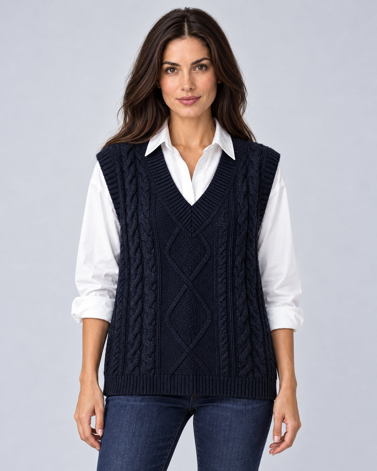 Women's black cable-knit V-neck sweater vest, front view over a white shirt
