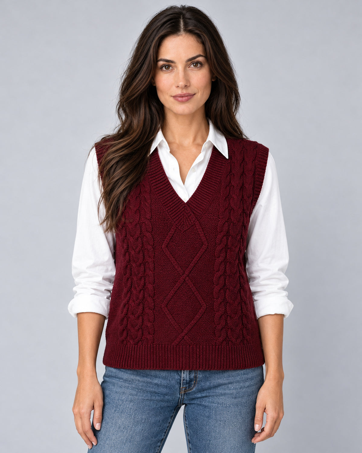 Women's burgundy cable-knit V-neck sweater vest, front view over a white shirt