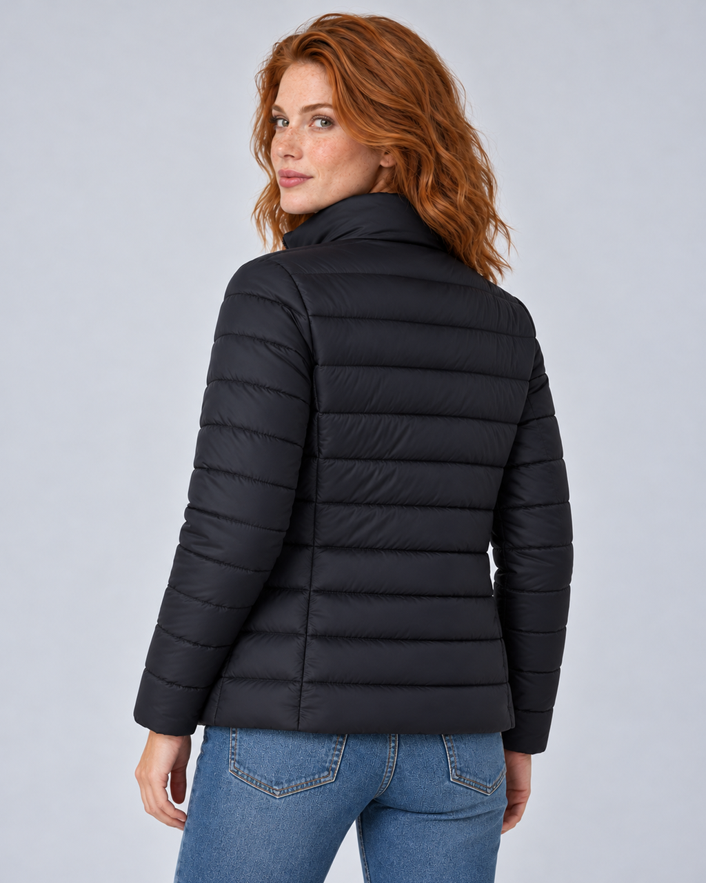Rear view of a black lightweight puffer jacket showing its horizontal quilting and fitted back panels.