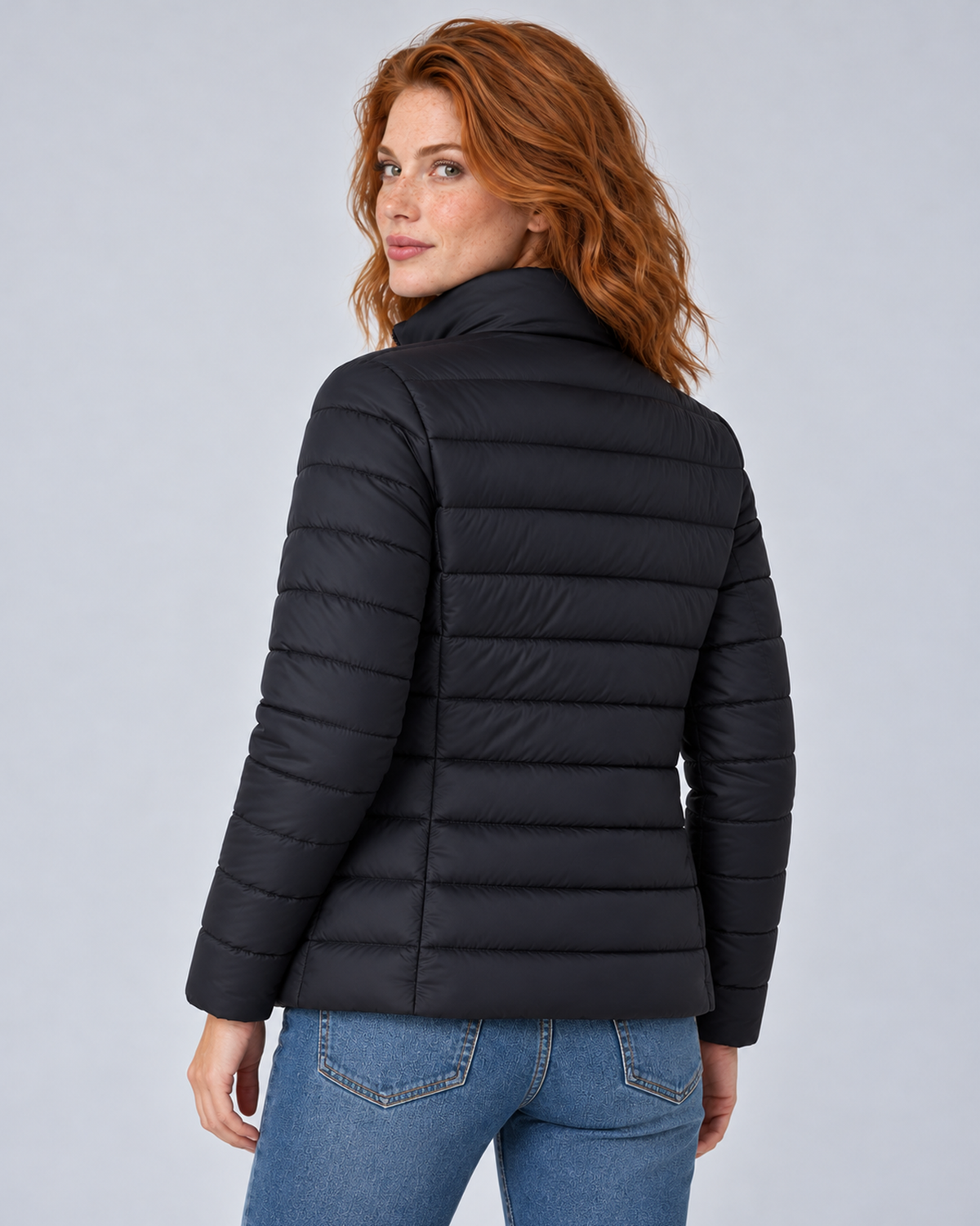 Rear view of a black lightweight puffer jacket showing its horizontal quilting and fitted back panels.