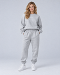 Front view of a grey crewneck sweatshirt and cuffed joggers set with small embroidered lettering.