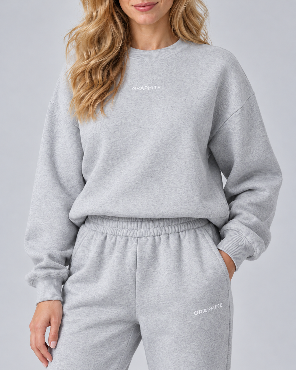 Close-up of the grey set showing the crew neckline, cuff, elastic waistband, side pocket and embroidered lettering.