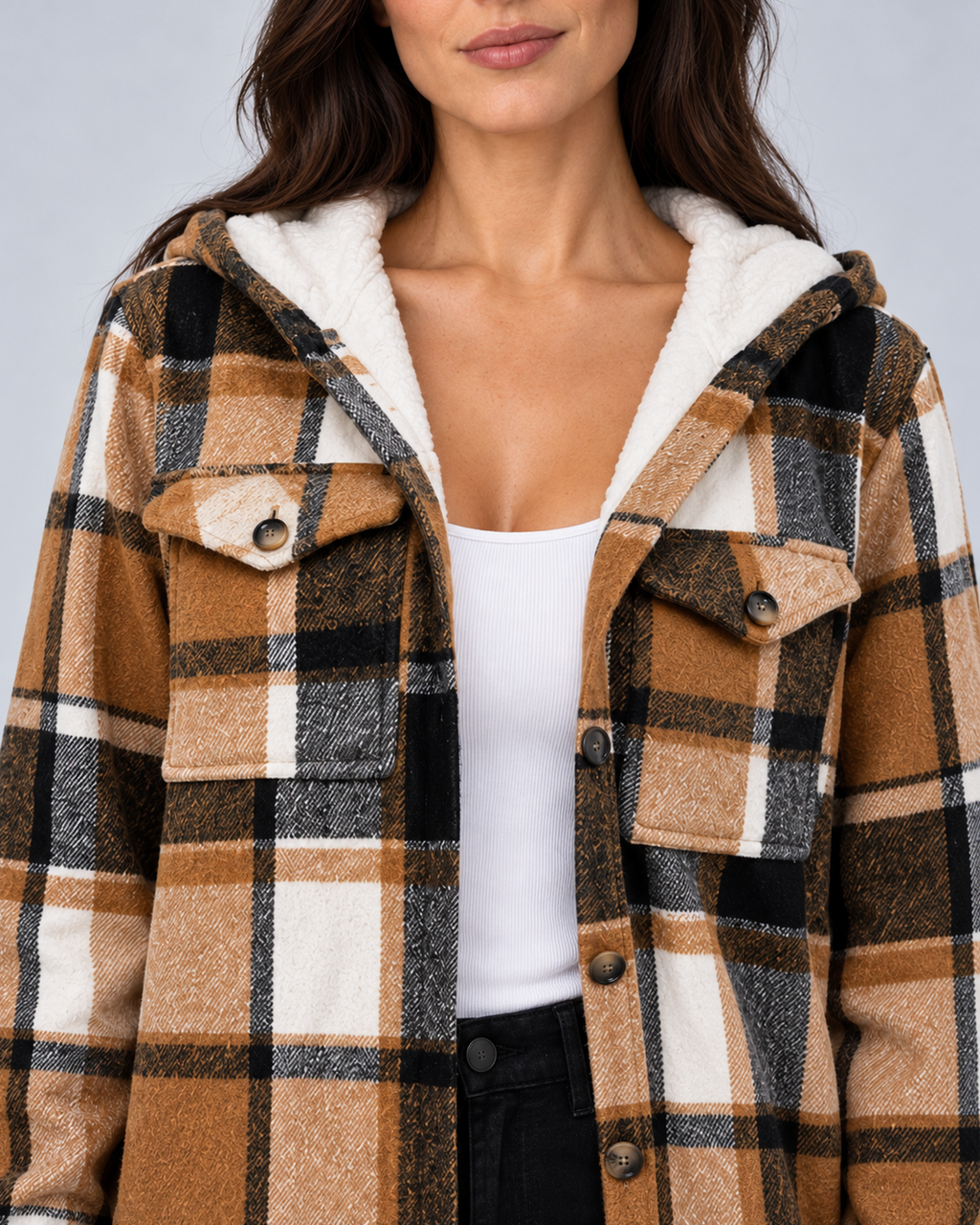 Close-up of the white fleece-lined hood, plaid fabric and button-flap chest pockets on a khaki coat.