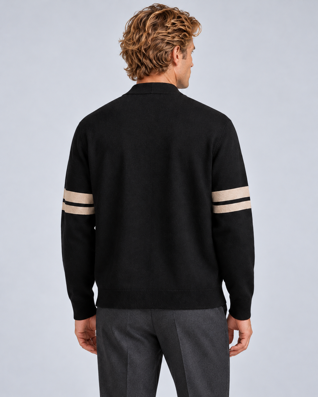 Men's V-neck button-front knit cardigan in black with contrast sleeve stripes, rear view, on a studio model