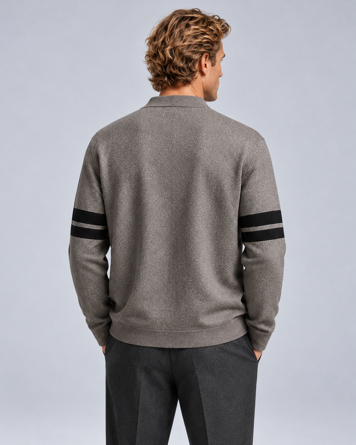 Men's V-neck button-front knit cardigan in grey with contrast sleeve stripes, rear view, on a studio model