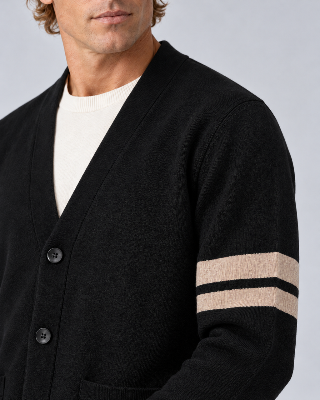 Men's V-neck button-front knit cardigan in black with contrast sleeve stripes, sleeve and knit detail, on a studio model