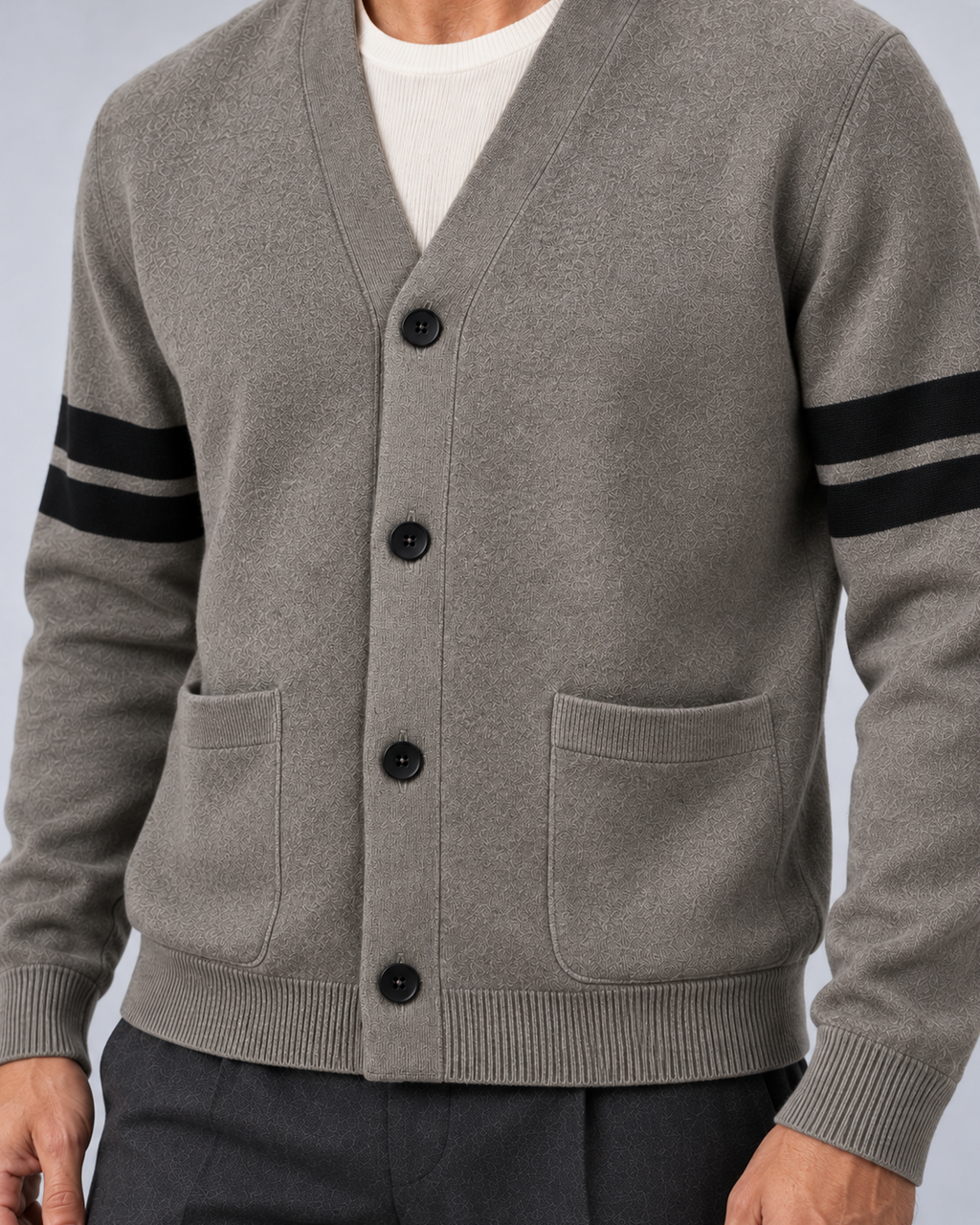Men's V-neck button-front knit cardigan in grey with contrast sleeve stripes, button and pocket detail, on a studio model
