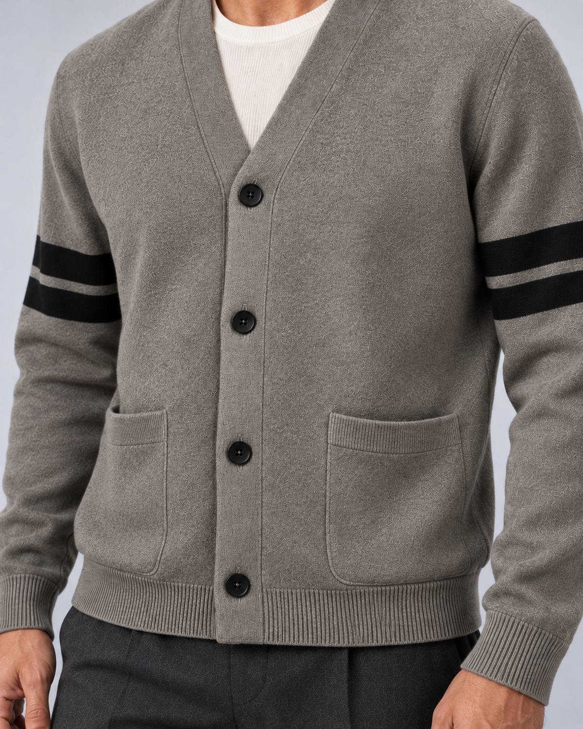 Men's V-neck button-front knit cardigan in grey with contrast sleeve stripes, button and pocket detail, on a studio model