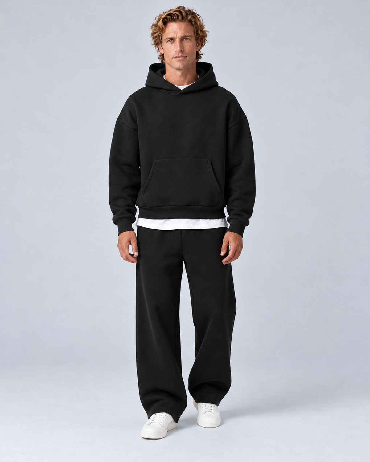 Men's pullover hoodie and straight-leg tracksuit set in black, front hero, on approved studio model