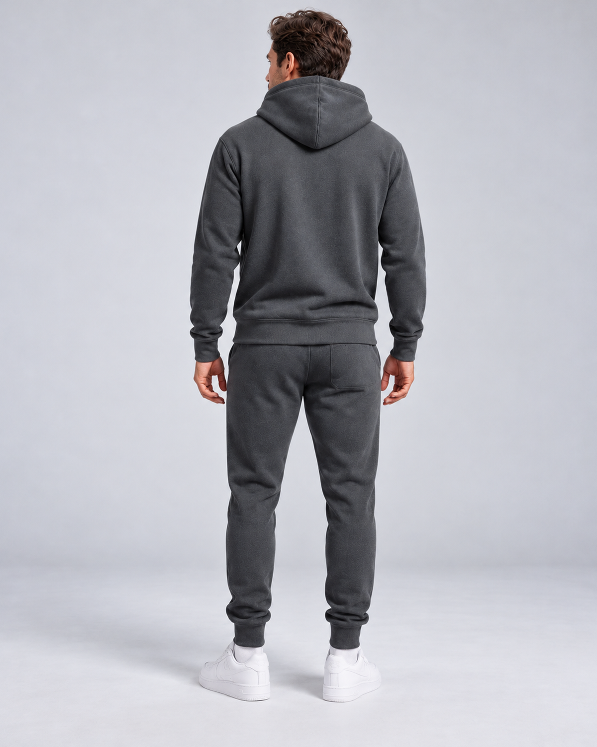 Men's pullover hoodie and cuffed jogger set in dark grey, rear full-length, on approved studio model