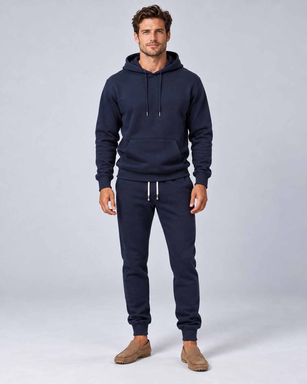 Men's pullover hoodie and cuffed jogger set in navy, front hero, on approved studio model