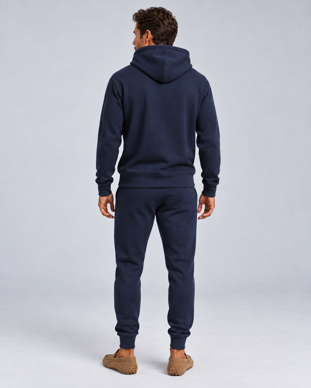 Men's pullover hoodie and cuffed jogger set in navy, rear full-length, on approved studio model